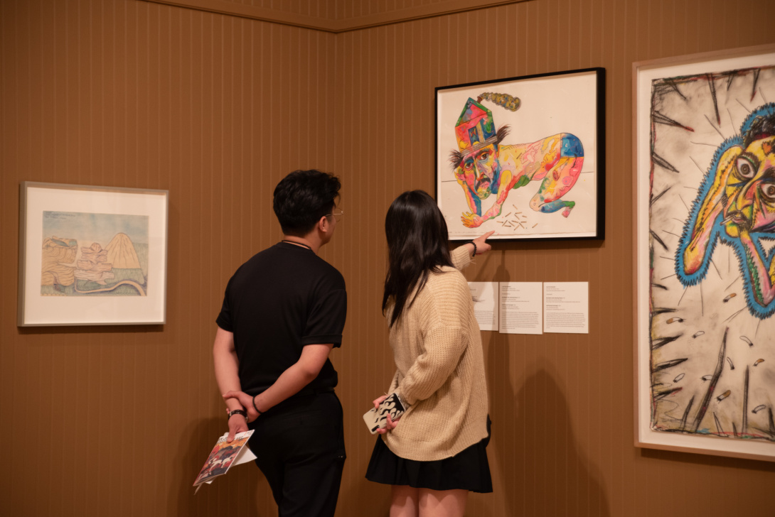 two visitors pointing at a work of art