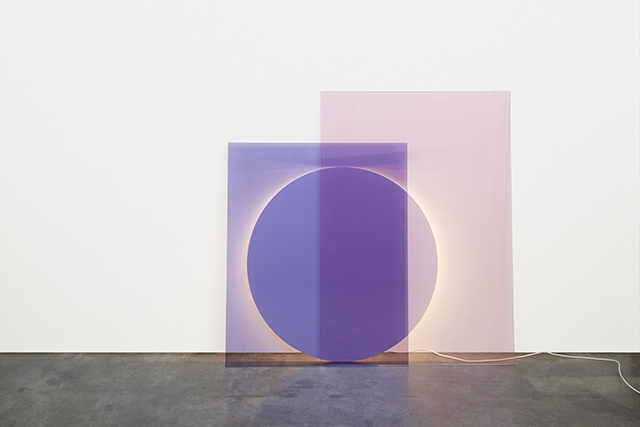 Massive purple rectangles and a circle of varying translucency leaning against a white wall. A glowing ring around the edges of the circle indicates that the structure is a lamp. A white cable twists away and out of view.