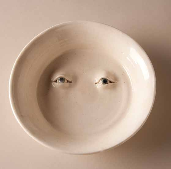 A white ceramic plate. On it are curious looking eyes, which resemble a human's eyes. Although it may seem like they are devoid of emotion, upon closer inspection they seem to be staring into one's soul, contemplating the nature of it.