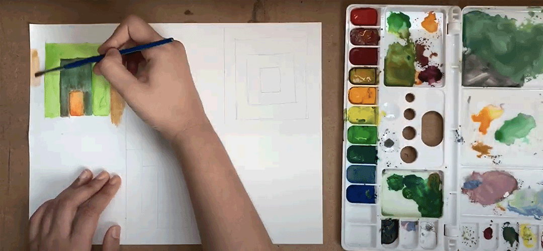 Video still of someone using a brush to paint with watercolors.