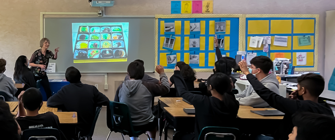 Toby Fernald presenting at George M. Shirakawa, Sr. Elementary. Maria Rivero's 7th grade class enjoys an Art in the Dark presentation with art from the SJMA exhibition, <i> Nuts and Who’s: A Candy Store Sampler. </i> Photograph by Marcia Klein. May 31st, 2023