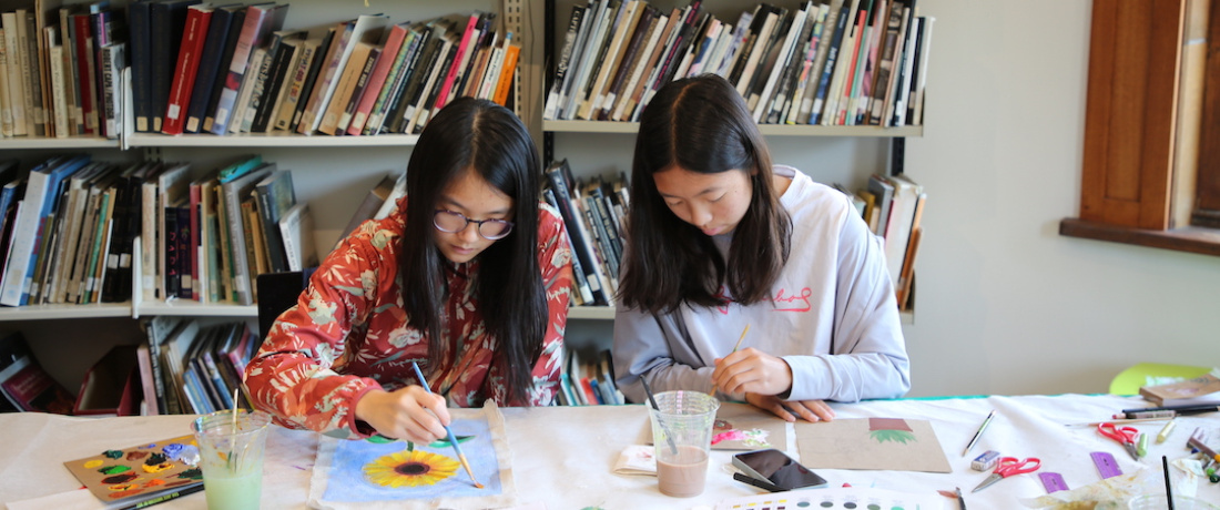 two teens painting flowers with watercolors