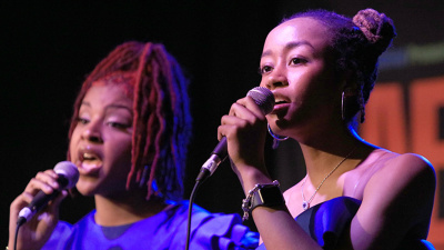 Two youth girls singing with mics.