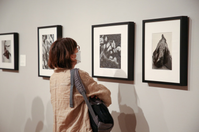 Woman looking at black and white photos in a gallery.