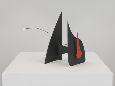  A modern art sculpture featuring two large, angular black shapes intersected by a red, elongated clockhand, and a thin wire extending from one side, ending with a small white sphere