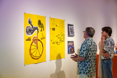 father and teenage son looking at an artistic graphic poster with vinyls