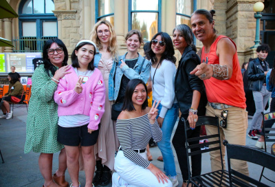 group of people posing with peace signs and one man pointing forward