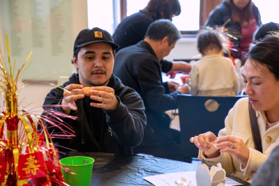 museum staff demonstrating an art activity to a visitor