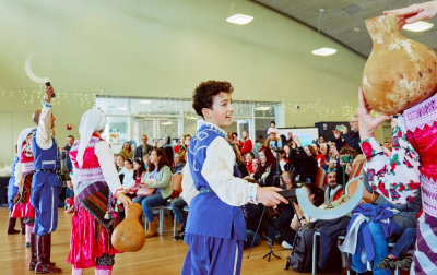 children in traditional ethnic costume performing for a crowd