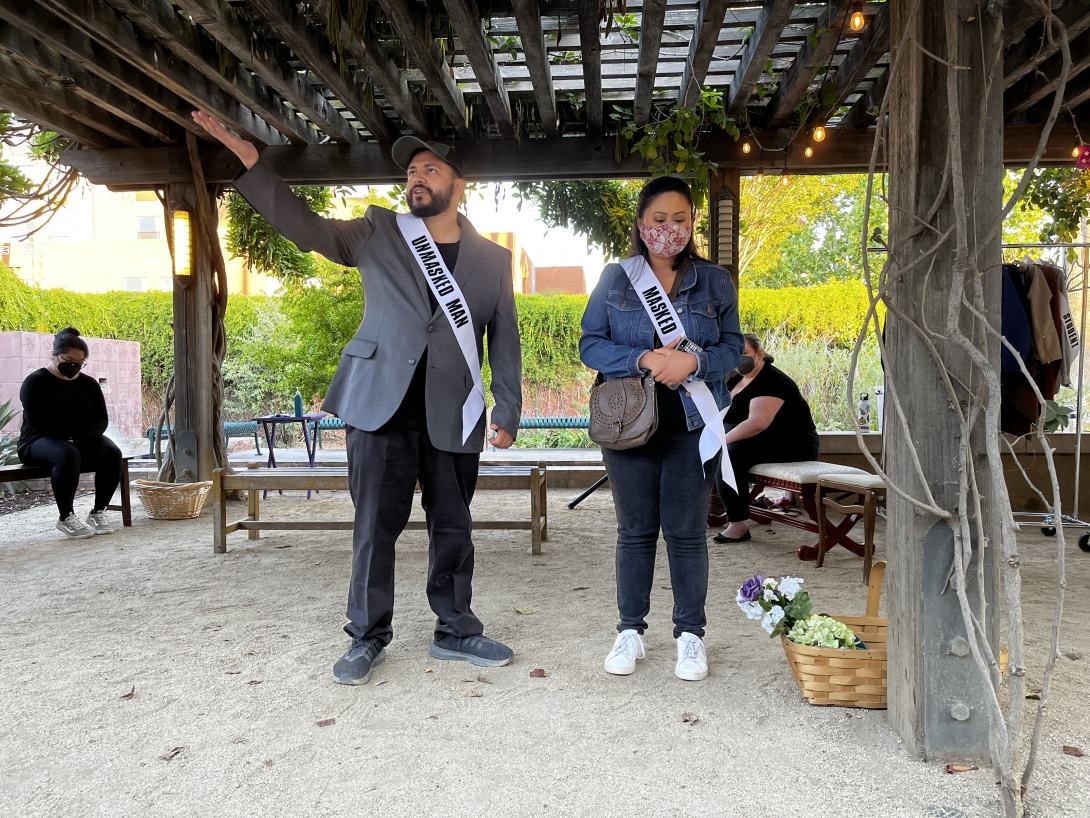 Two actors performing in an outdoor stage.