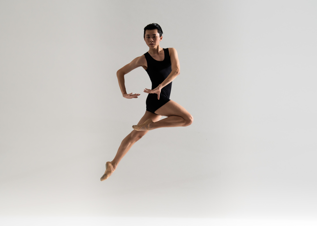 Asian male ballet dancer posing in the air.