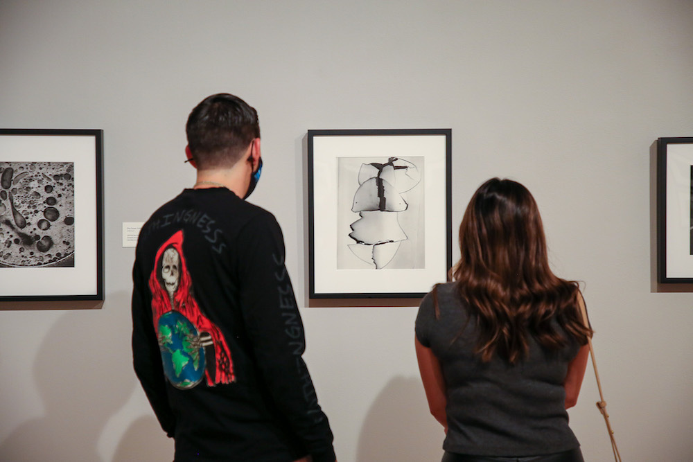 Two visitors looking at an photograph.