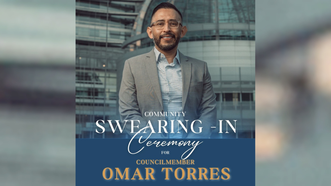 A man smiles wearing glasses and a grey suit, standing in front of dome shaped building. Text laid over the image reads: Community Swearing-in Ceremony for Councilmember Omar Torres.