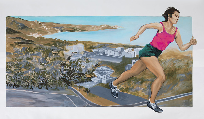 Woman running on a path along the San Diego coastline.