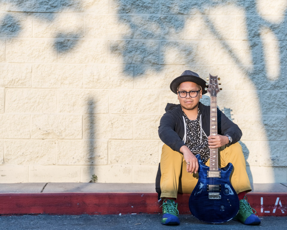 man with guitar on curb