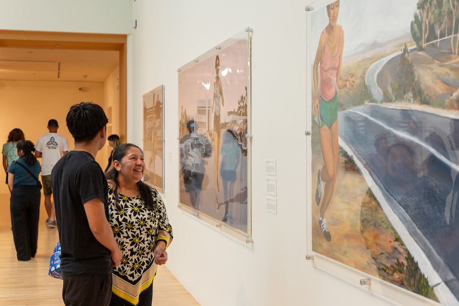 two visitors looking at an artwork of a woman running