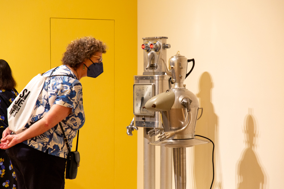 Visitor looking at two robotic sculptures