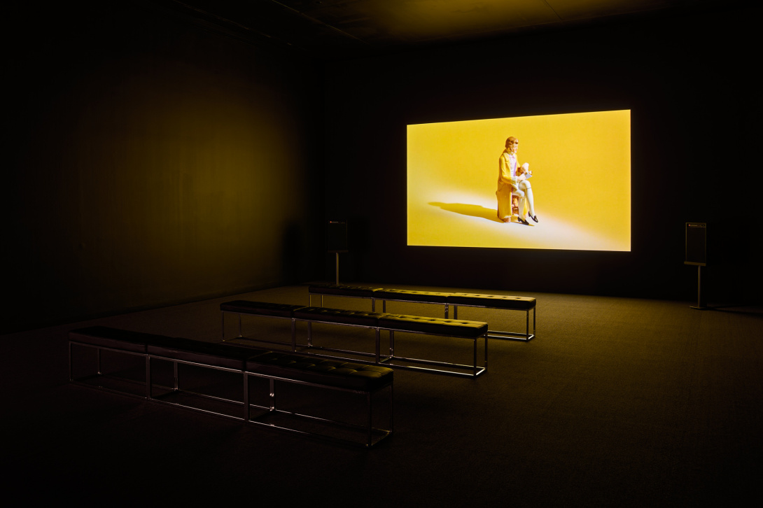 a black box theater with a film projection of a porcelain figurine sitting down