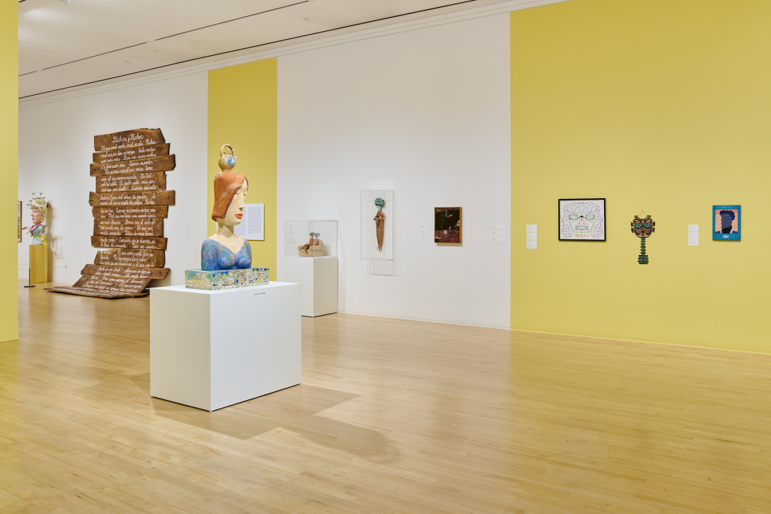 gallery installation view with multi-colored walls and eccentric sculpture in front