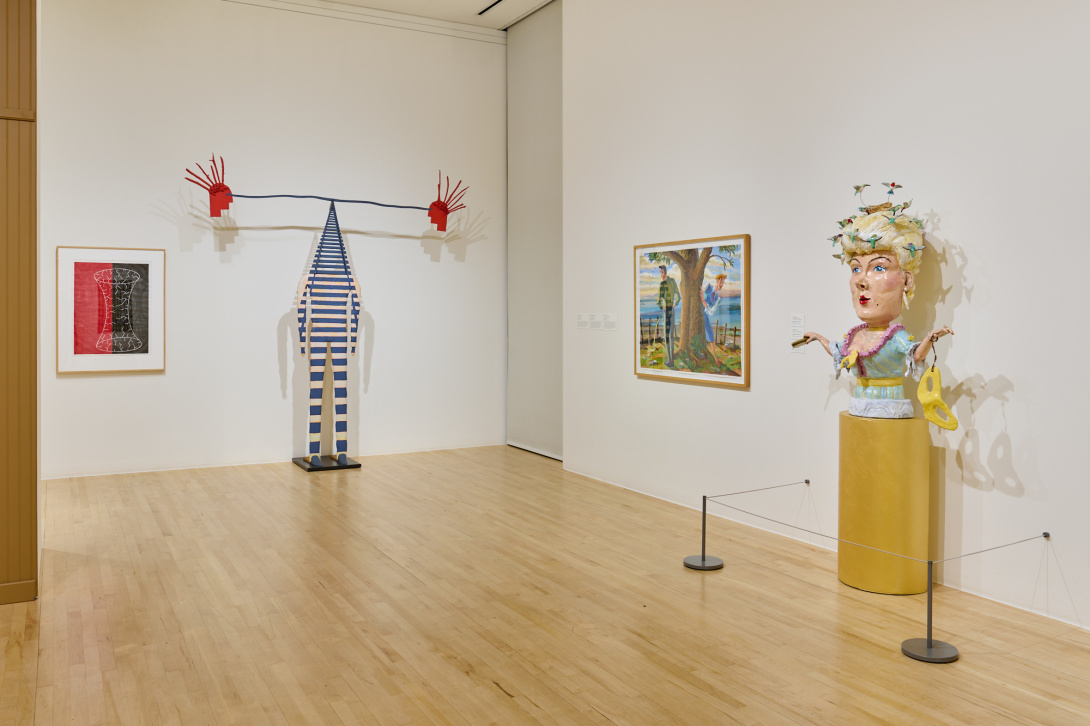 gallery installation view with multi-colored walls and eccentric sculptures and works on paper