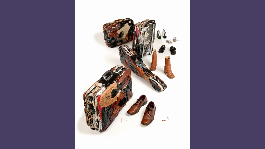 sculptures of three luggage pieces and a guitar case constructed of compacted shoes