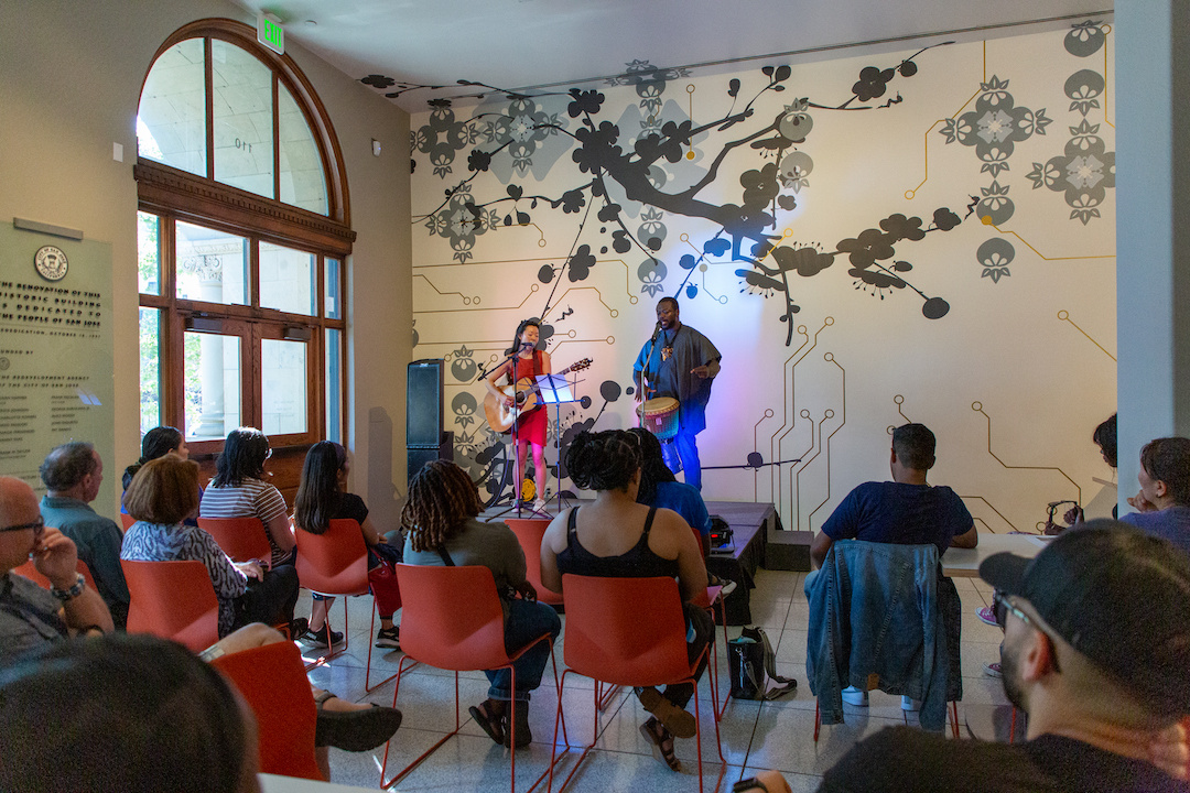 two performers on stage at the museum