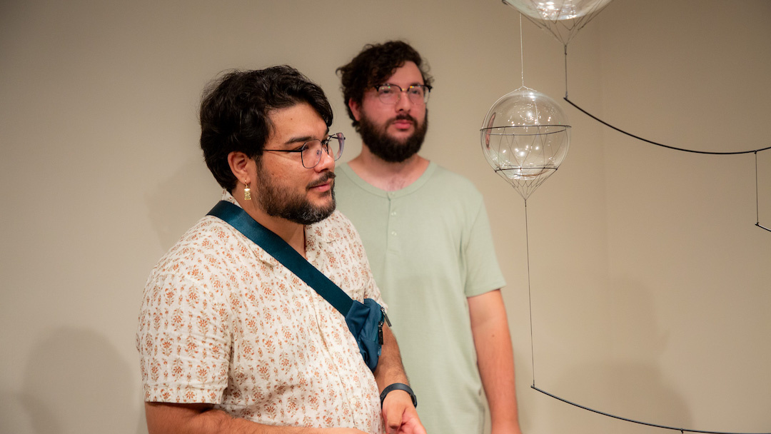 visitors gazing intently at a glass orb