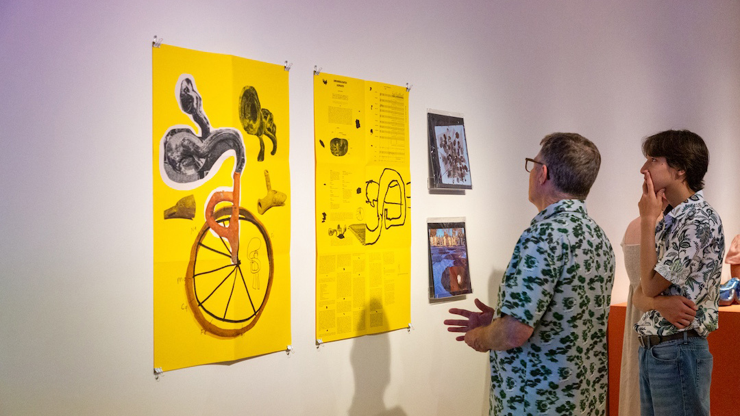 father and teenage son looking at an artistic graphic poster with vinyls