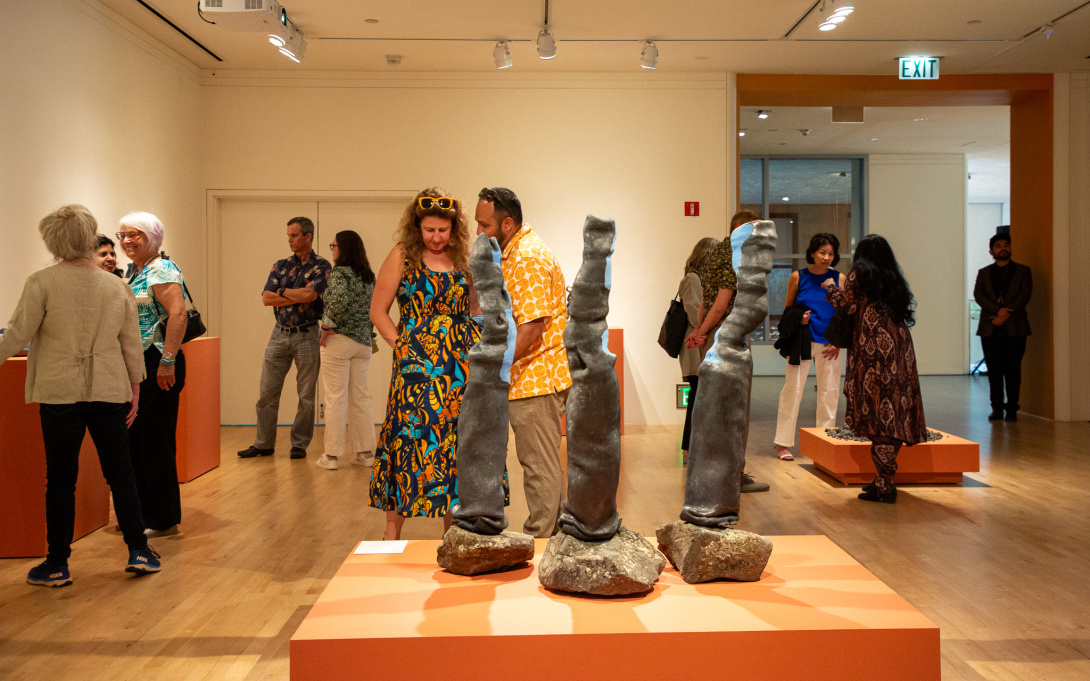 visitors in a gallery looking at abstract and colorful ceramic sculptures