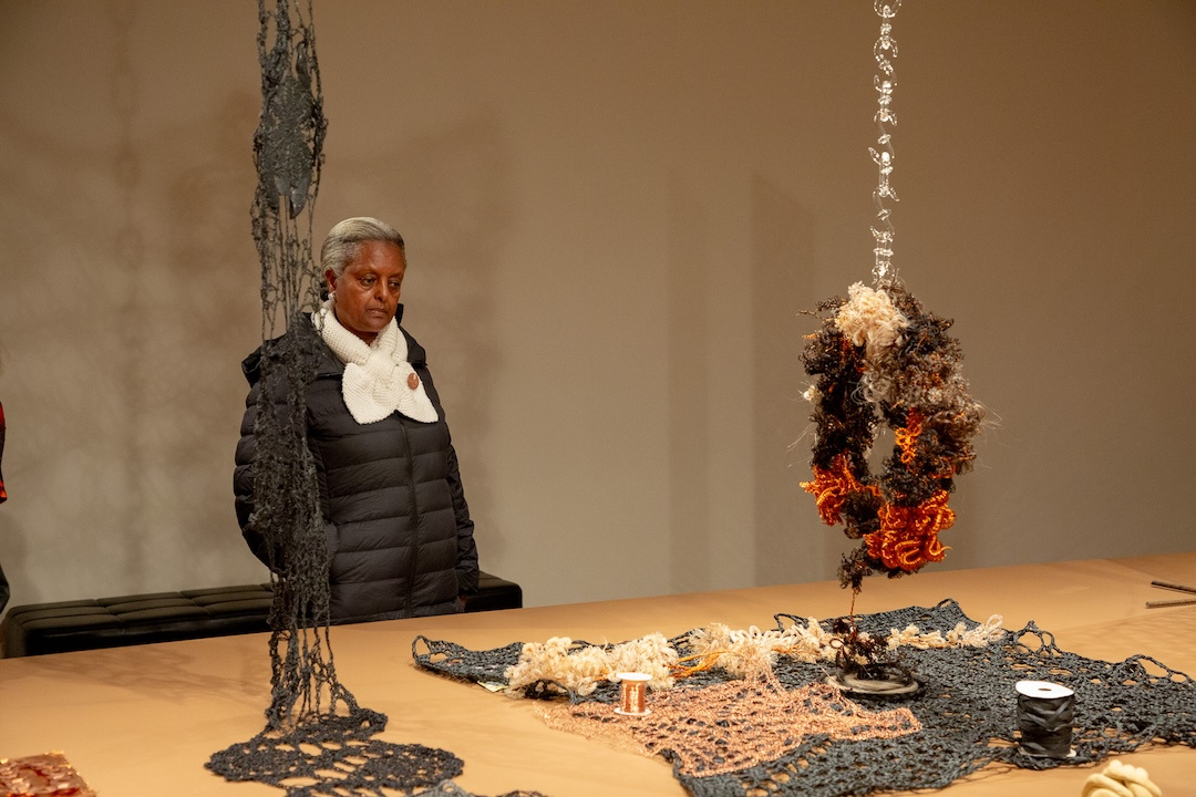 visitor gazing intently at a suspended crochet wreath