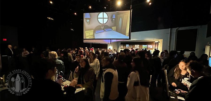 dark gallery busy with students with a screen with projected computer-generated imagery