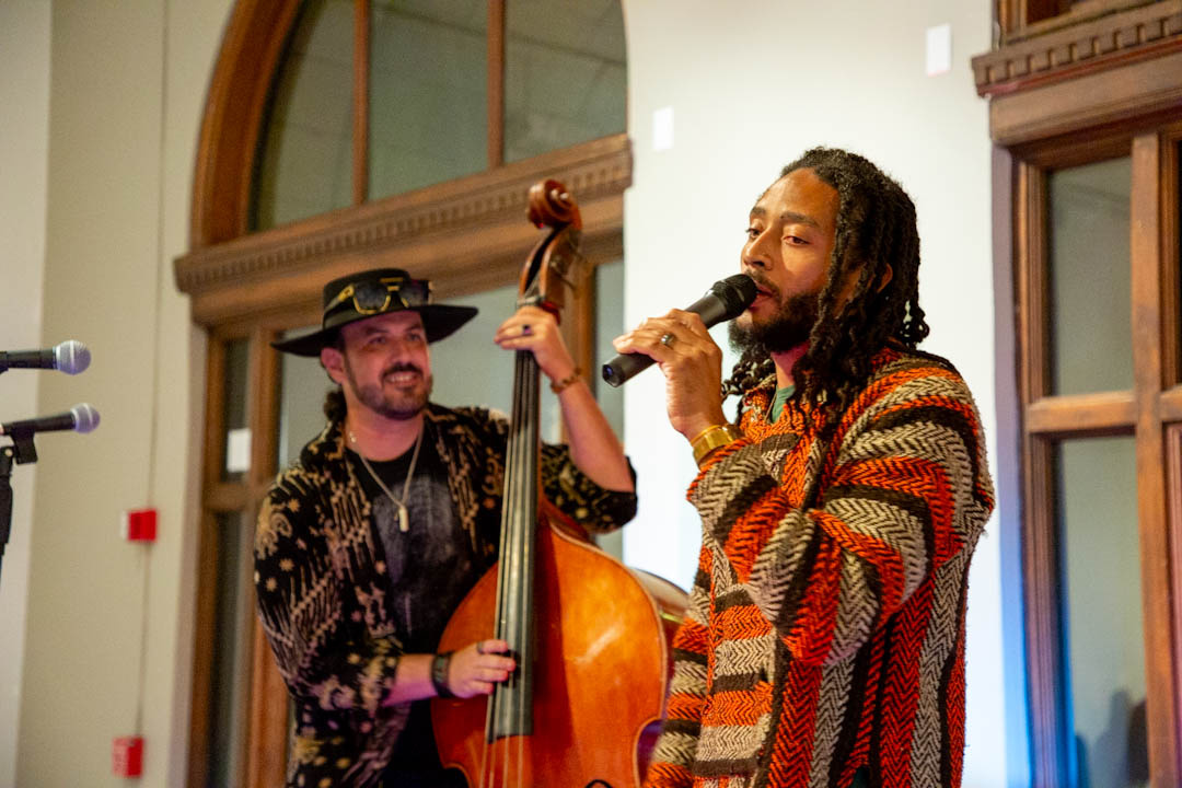 Man with bass and a man with dreads on a microphone