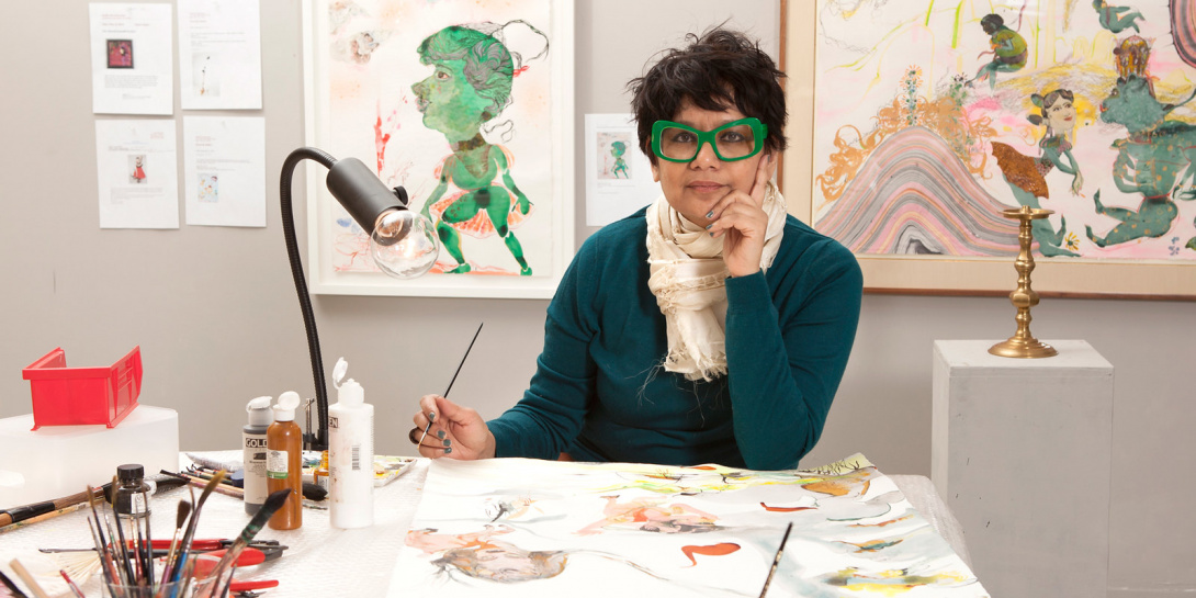 South Asian woman with fashionable spectacles in her artist studio painting.