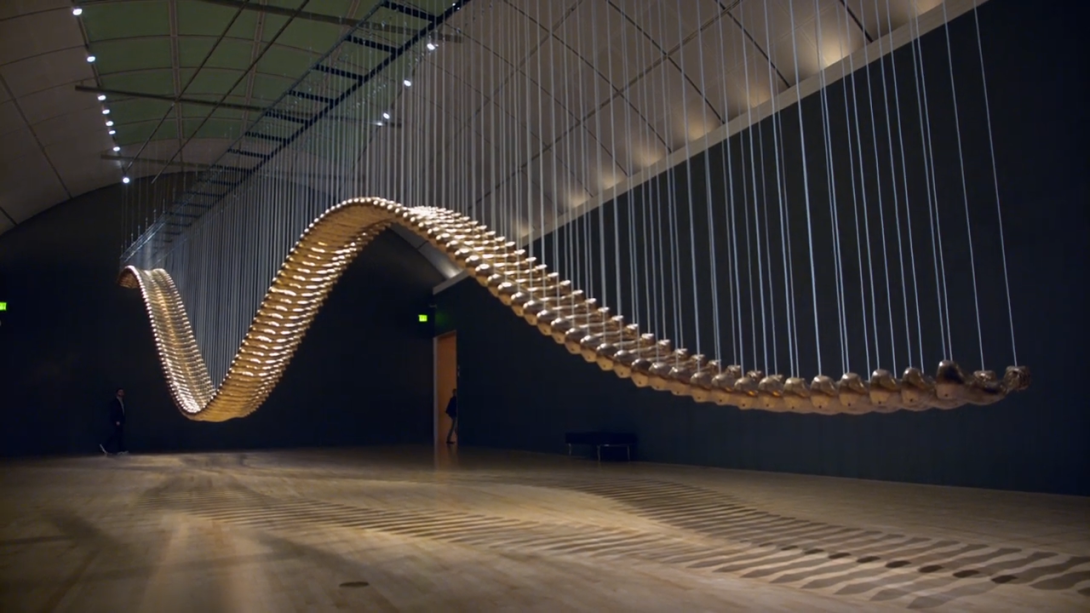 Installation of multiple golden arms across a large gallery.