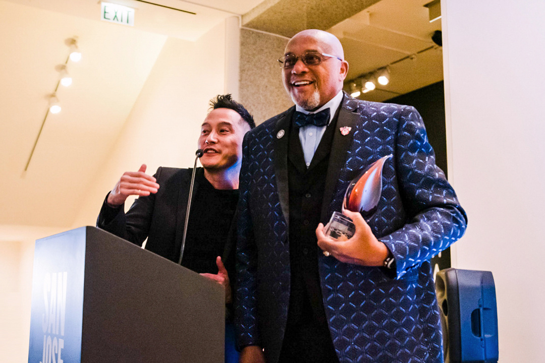 Tommie Smith in Museum lobby holding award.