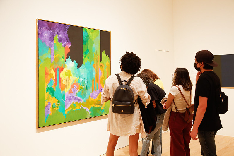 Group of teenagers looking at a painting.