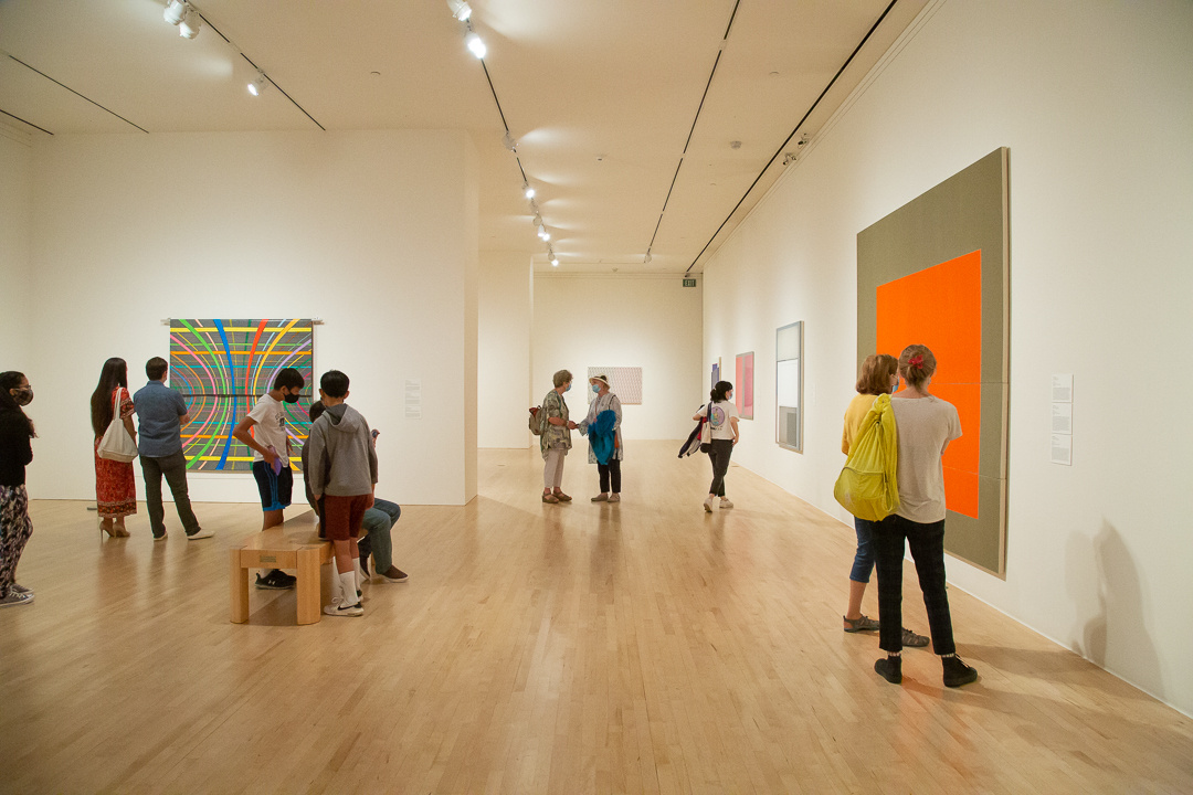 People looking at abstract works in a gallery.