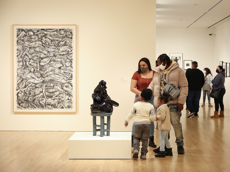 A family of four looking at a sculpture.
