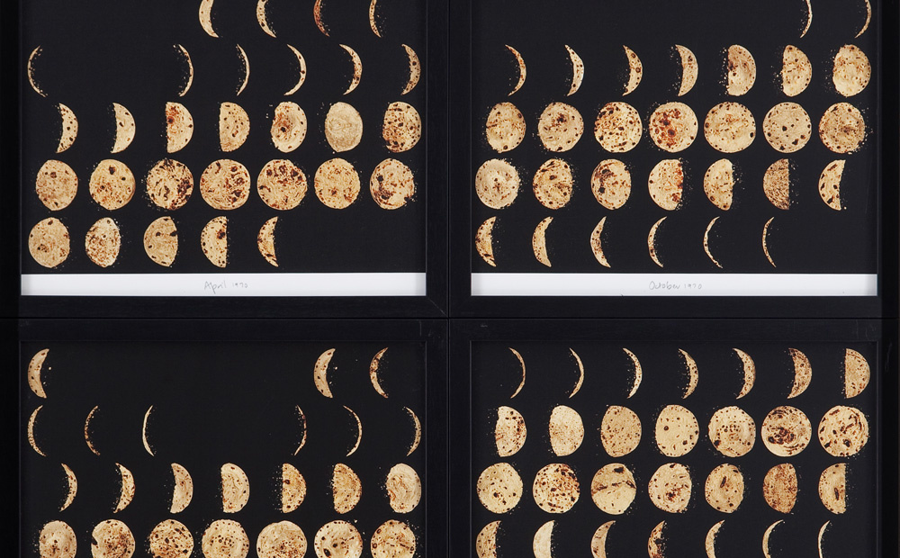 A photograph of four frames that contain 5 rows and 7 columns depicting the phases of the moon. Each frame is a different month. The background of the frames is black and the different phases of the moon are golden.