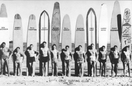 A black and white photograph of surfers standing in front of their long boards at a beach. A caption reads Santa Cruz Surfing Club, June, 1941. Their names are superimposed over their surfboards, some of which are almost 3 times as tall as the surfers!