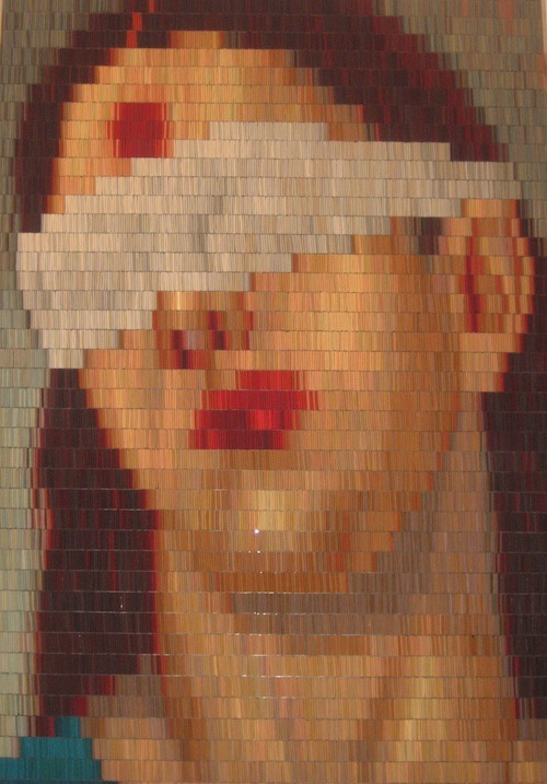 Pixelated portrait of a long haired person with their head tilted to the left side. A white blindfold obscures the figures identity, their only defining feature being their full red lips. Paralleling the large lips are an equally red mark on their forehead.