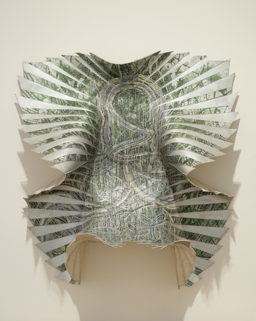 A three-dimensional abstract sculpture which appears to be coming to life and peeling itself free from the wall. The shape is decorated with thick dripping paint in organic shades and has an alternating design that is divided with silver wing shapes.