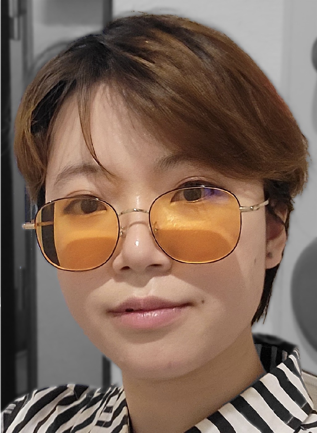 a person with short brown hair wearing colored glasses