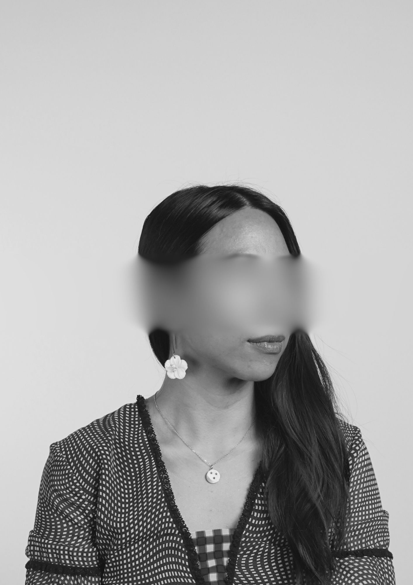 a dark haired woman with her eyes blurred 