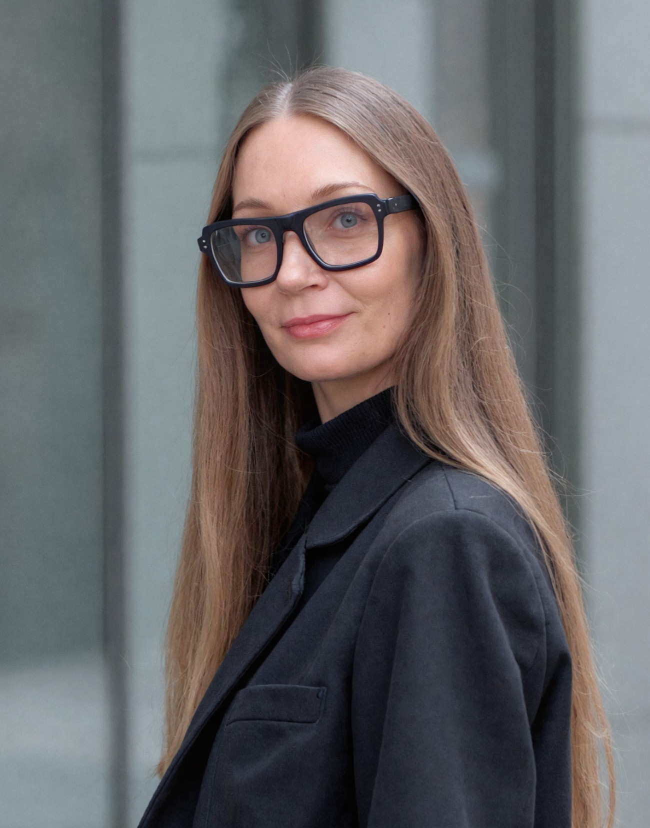 a woman with a long brown hear wearing square glasses