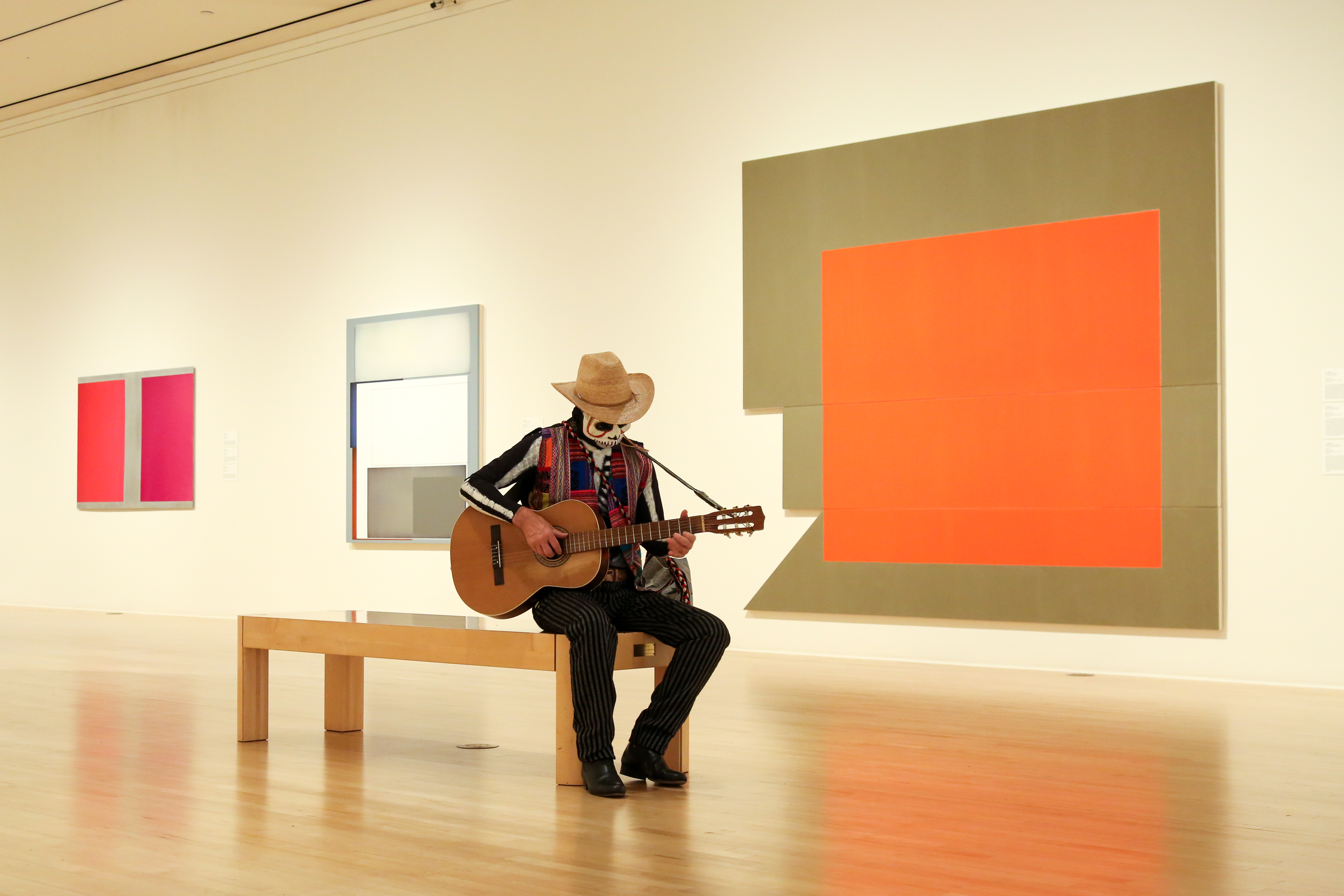 Man dressed as a skeleton playing a guitar in the galleries.