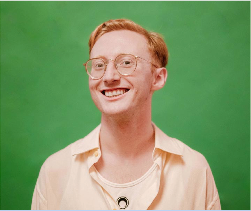 a man wearing round glasses with short red hair