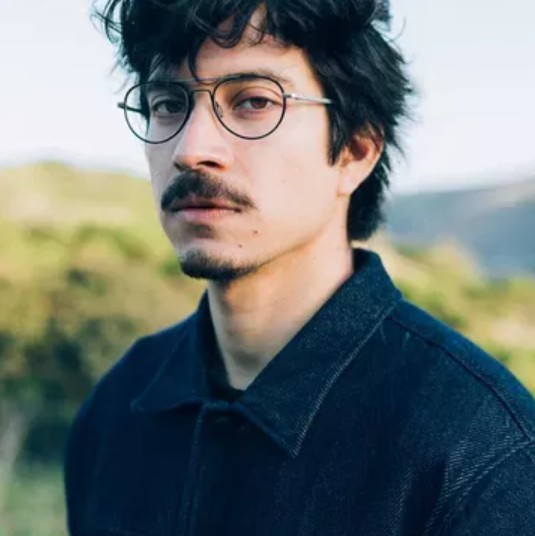 a spectacled man with a goatee